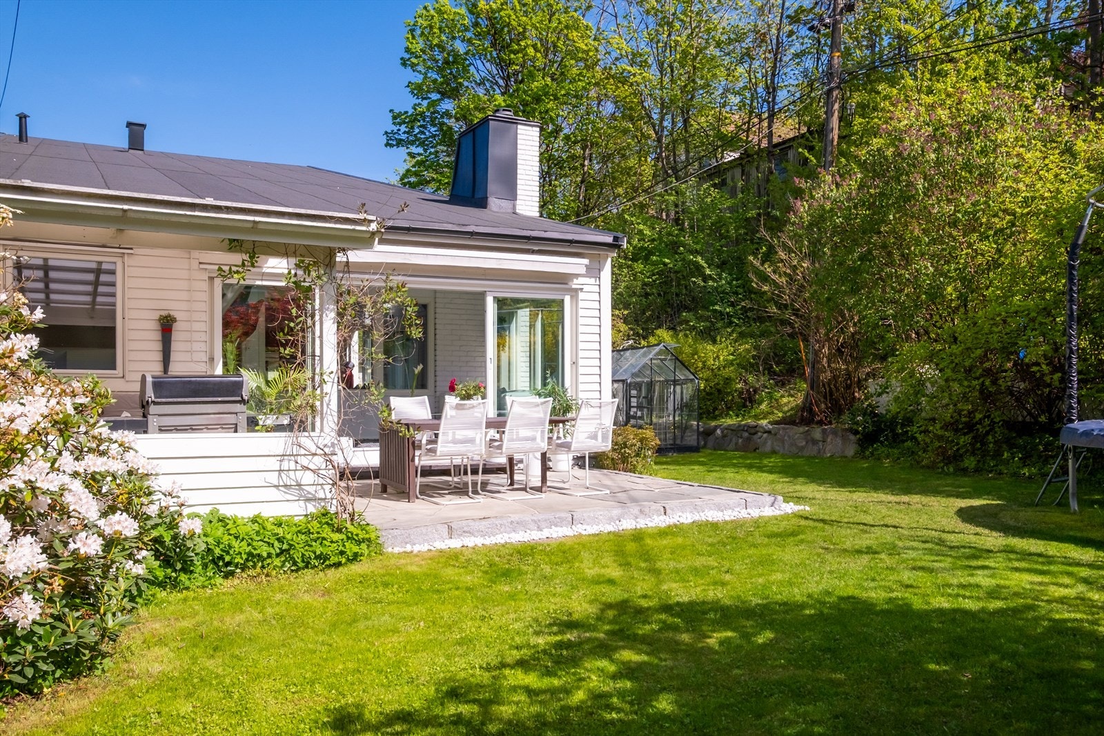 Selve tomten rundt huset er planert og meget pent opparbeidet med gressplen, busker og blomsterbed - En ideell tomt for barnefamilier med god boltringsplass. Galleribilde