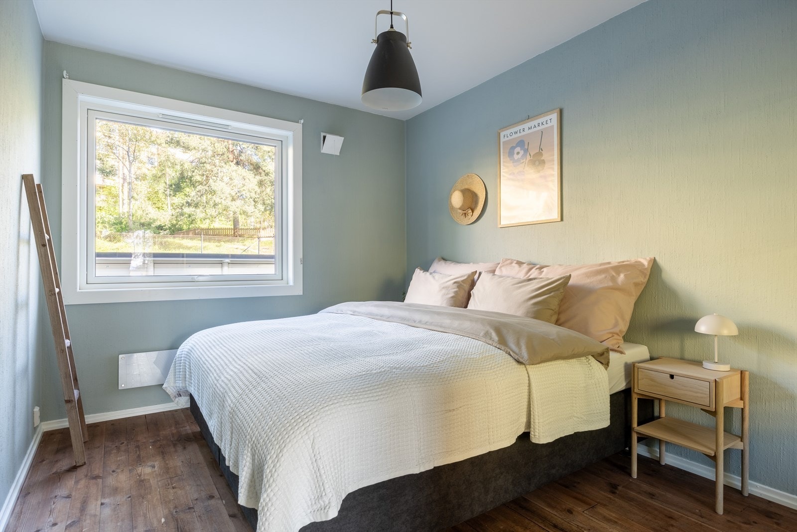 Luftig og romslig soverom med plass til dobbeltseng, nattbord og kommode Galleribilde