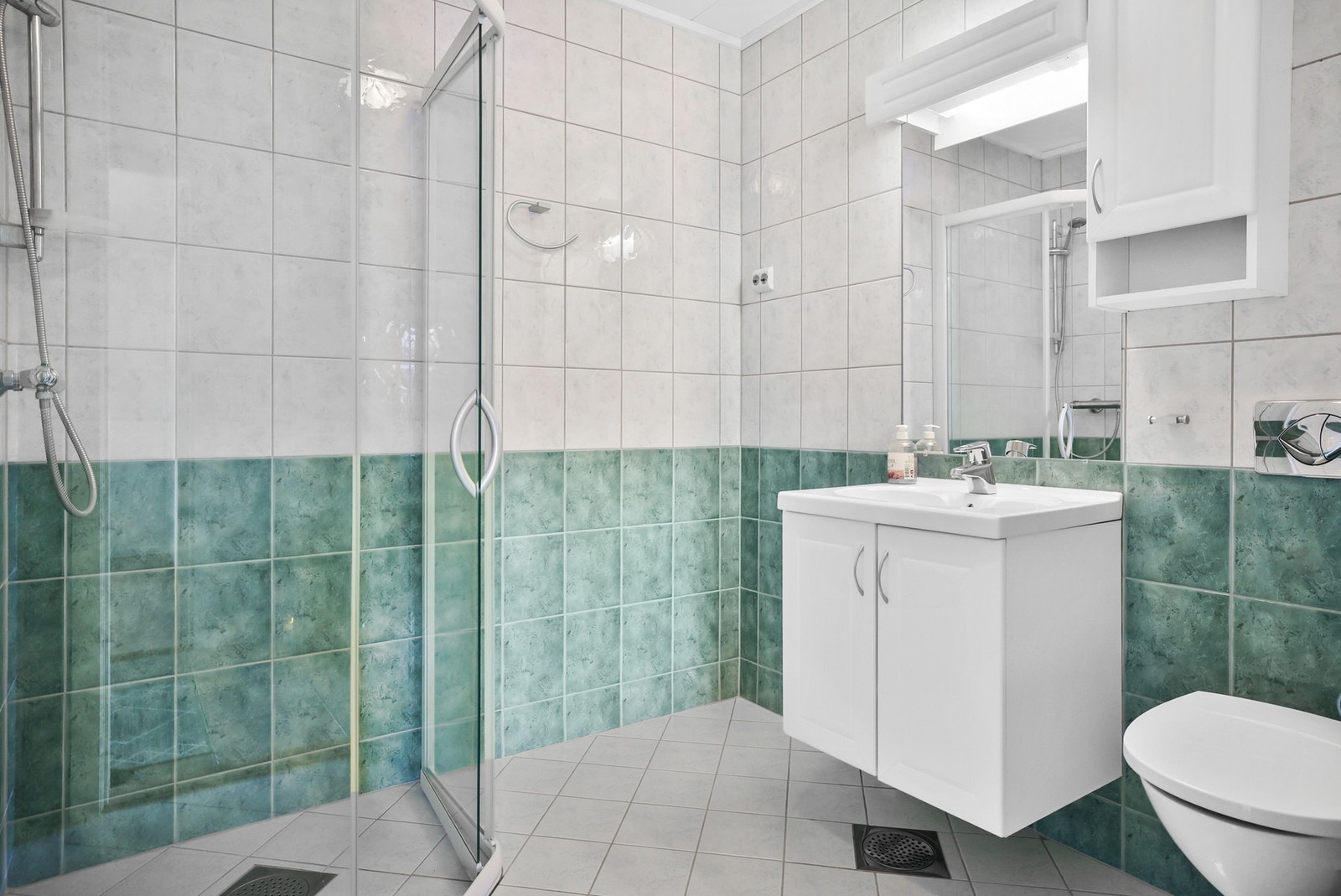 Baderommet fra 2007 er helflislagt med gulvvarme, og har servant, vegghengt toalett og dusj med glassvegger. Designet er enkelt, men praktisk, og mekanisk avtrekk sørger for et greit inneklima. Galleribilde