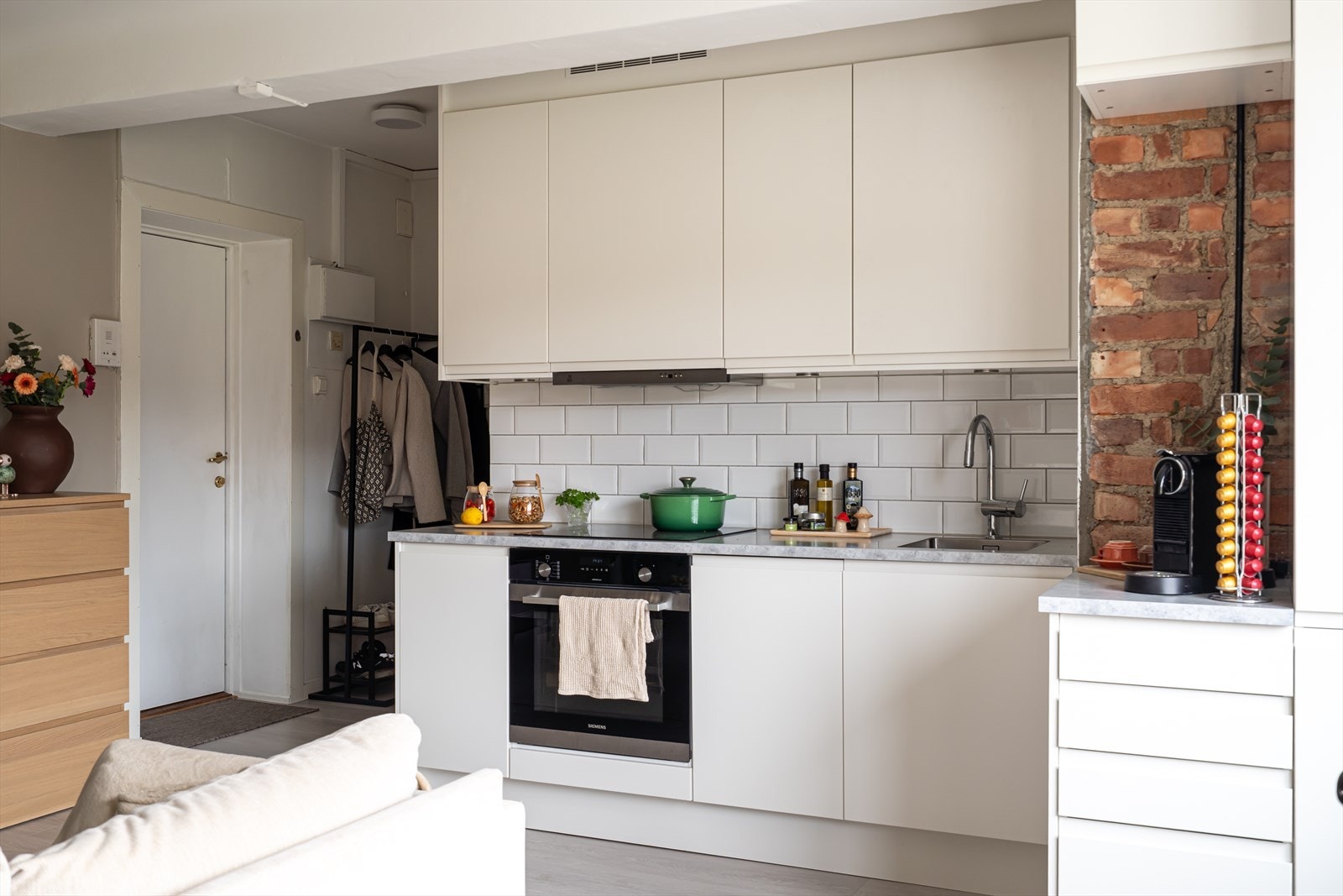 Integrerte hvitevarer inkluderer induksjonstopp, stekeovn, smal oppvaskmaskin og kjøl/frys. Galleribilde