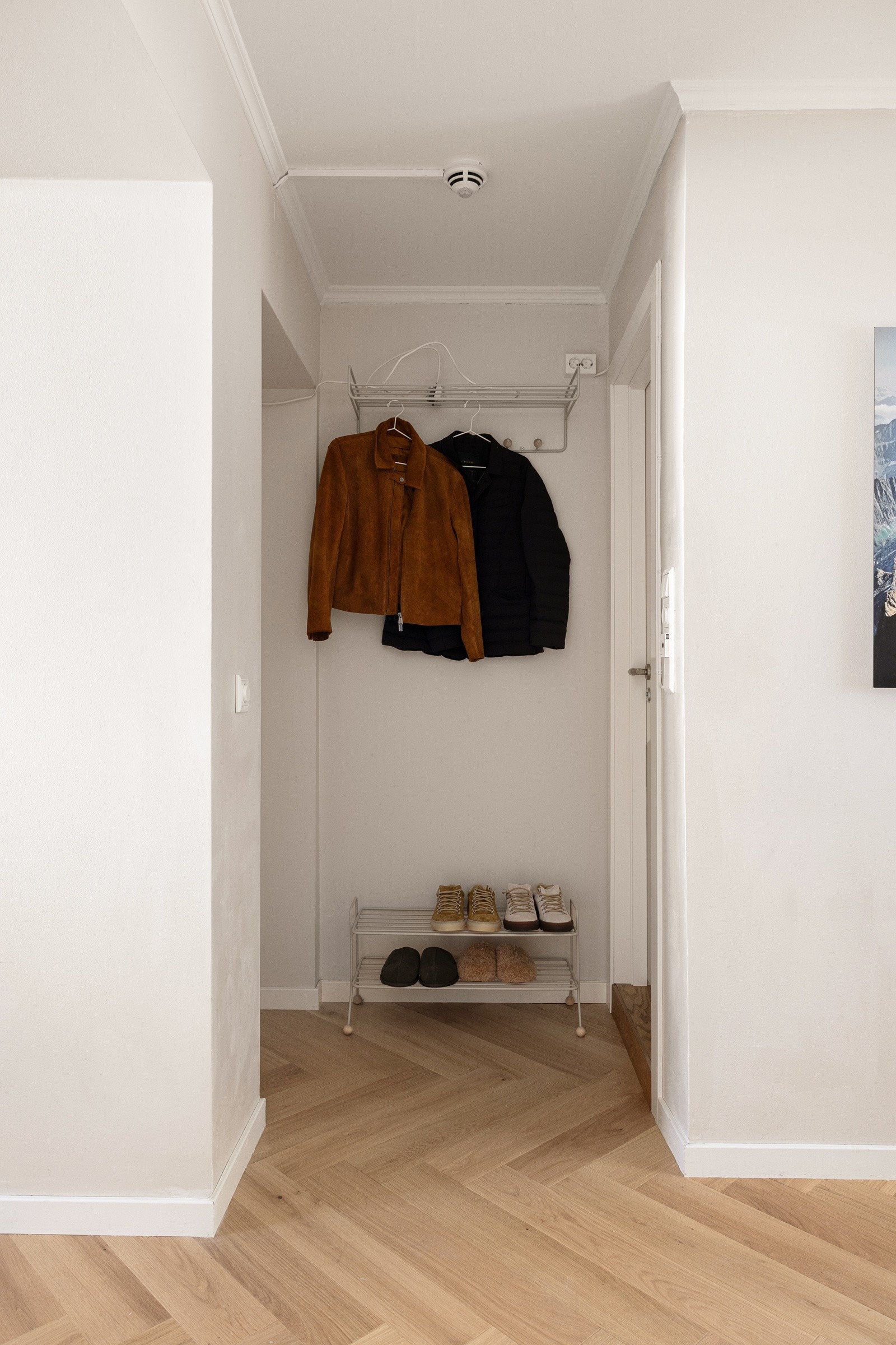 Innbydende entré med lekker fiskebensparkett og lyse fargevalg på vegger. Her er det god plass til oppheng av klær og plassering av sko. Galleribilde