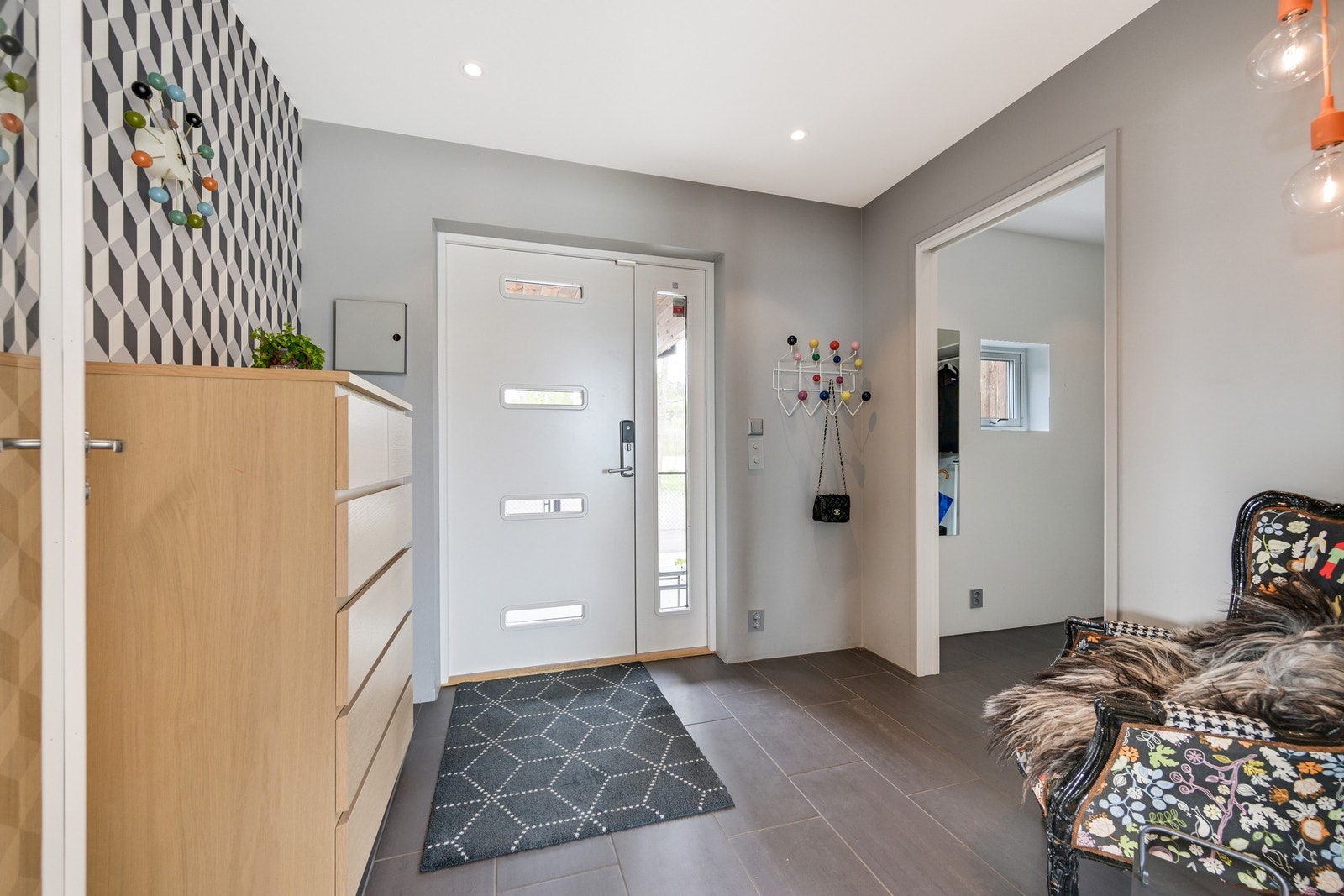 Vel inne gir entreen et flott førsteinntrykk, med downlights, mørke gulvfliser og kontrastvegg kledd i tapet. Fra entreen er det stor walk in garderobe med plass til alt av yttertøy og sko med hvit innredning fra Rival som i de andre garderobene Galleribilde