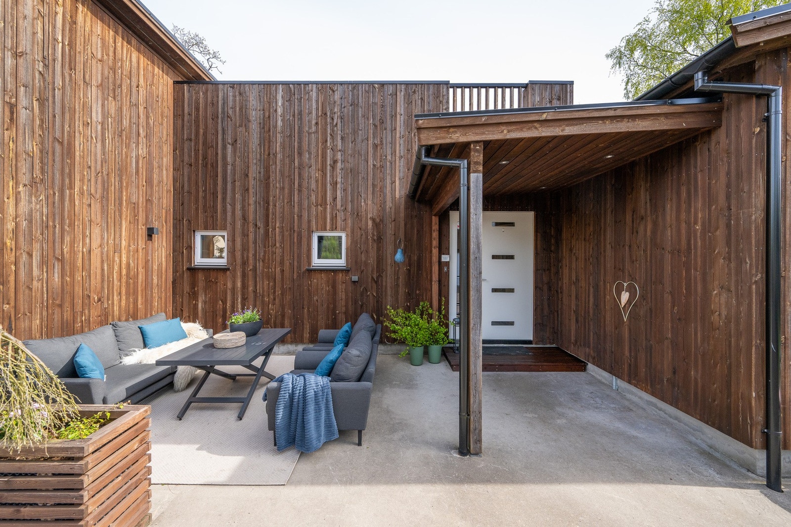 Inngangen er overbygd, utstyrt med downlights og varmekabler. Kveldstid er belysningen stemningsfull, og ved inngangen er det god plass til en stor sittegruppe. Galleribilde