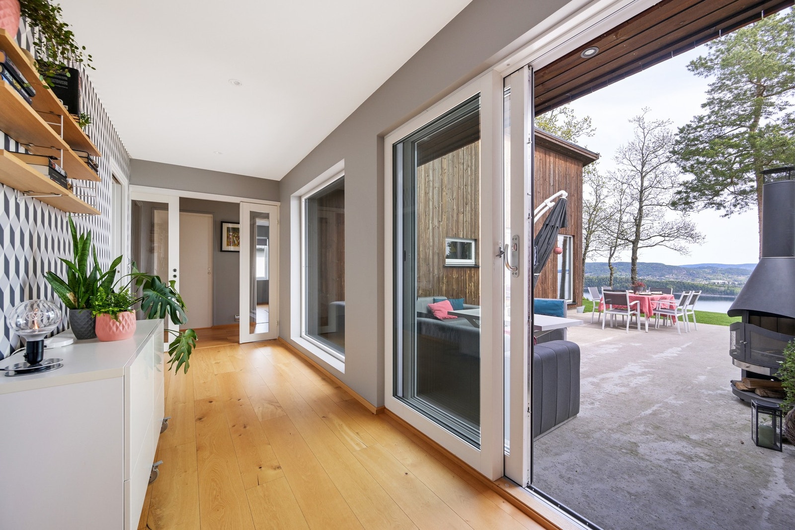 Utformingen av huset er stilig, og gangen innenfor entreen binder sammen to fløyer. Det er lagt samme parkett og fliser i alle rom for å skape en helhet Galleribilde