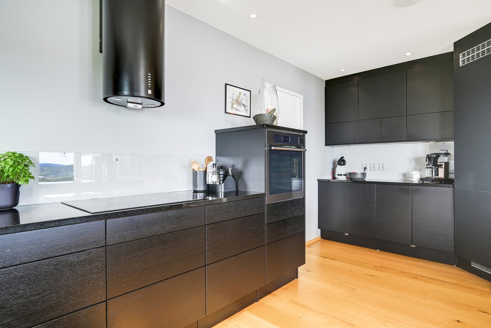 For et luftigere uttrykk er overskap i stor grad droppet til fordel for åpne flater og hyller, men det er likevel rikelig med skap- og benkeplass på kjøkkenet Galleribilde