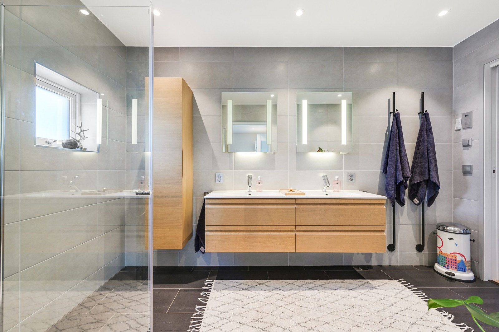 Badet har god størrelse, og et vindu kan åpnes for lufting. Et dusjhjørne har regnfallsdusj og innfellbare dører Galleribilde