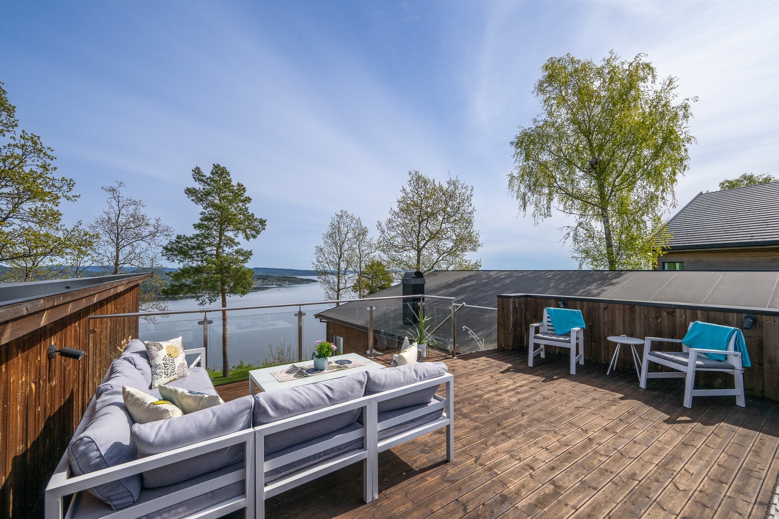 En trapp tar deg opp til en flott takterrasse, der glassflater langs rekkverket ivaretar den slående utsikten. Galleribilde