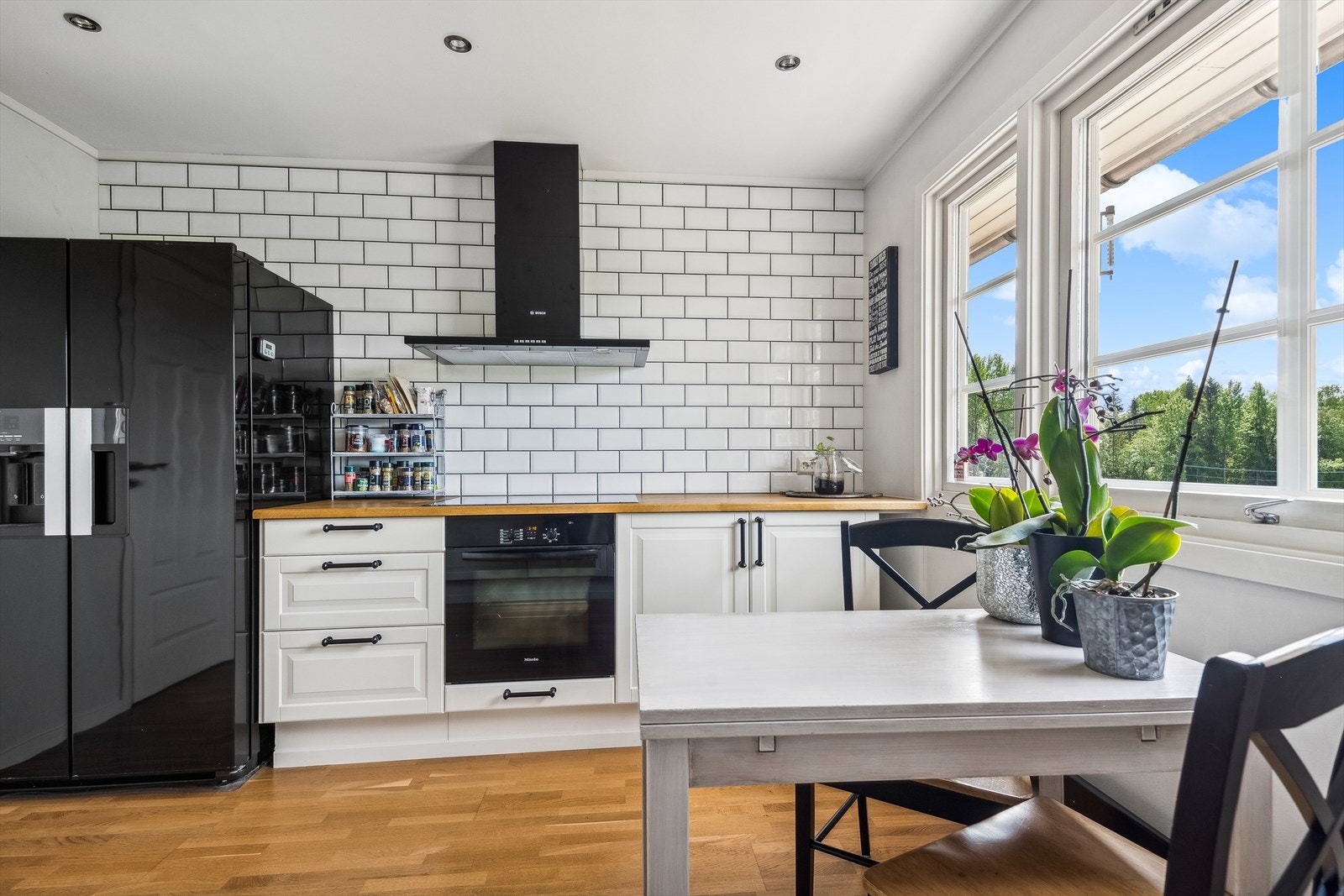 Kjøkkenet holder en klassisk stil med plass for spisebord ved vinduene. Downlights i himling Galleribilde