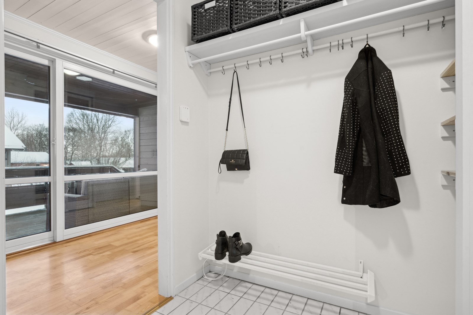 Man ønskes velkommen inn i en romslig entré og gang med flislagt gulv. Galleribilde