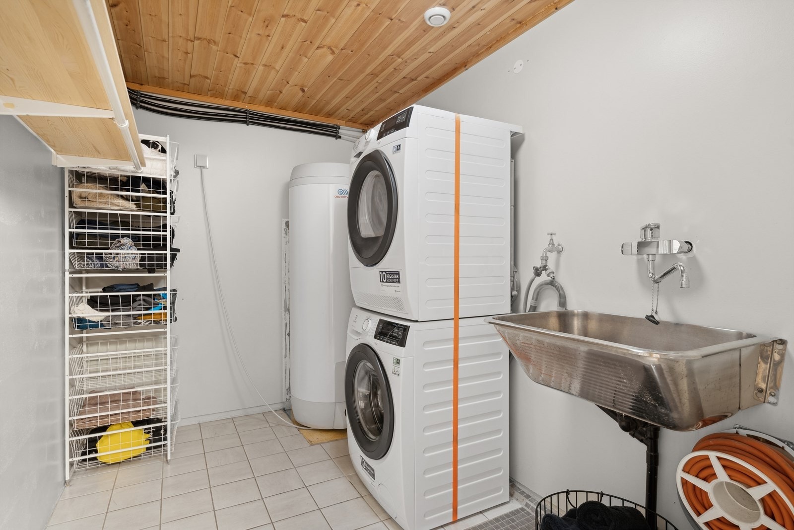 Kjelleren har separat vaskerom i underetg. med skyllekum, hyller og opplegg for vaskemaskin og tørketrommel. Galleribilde