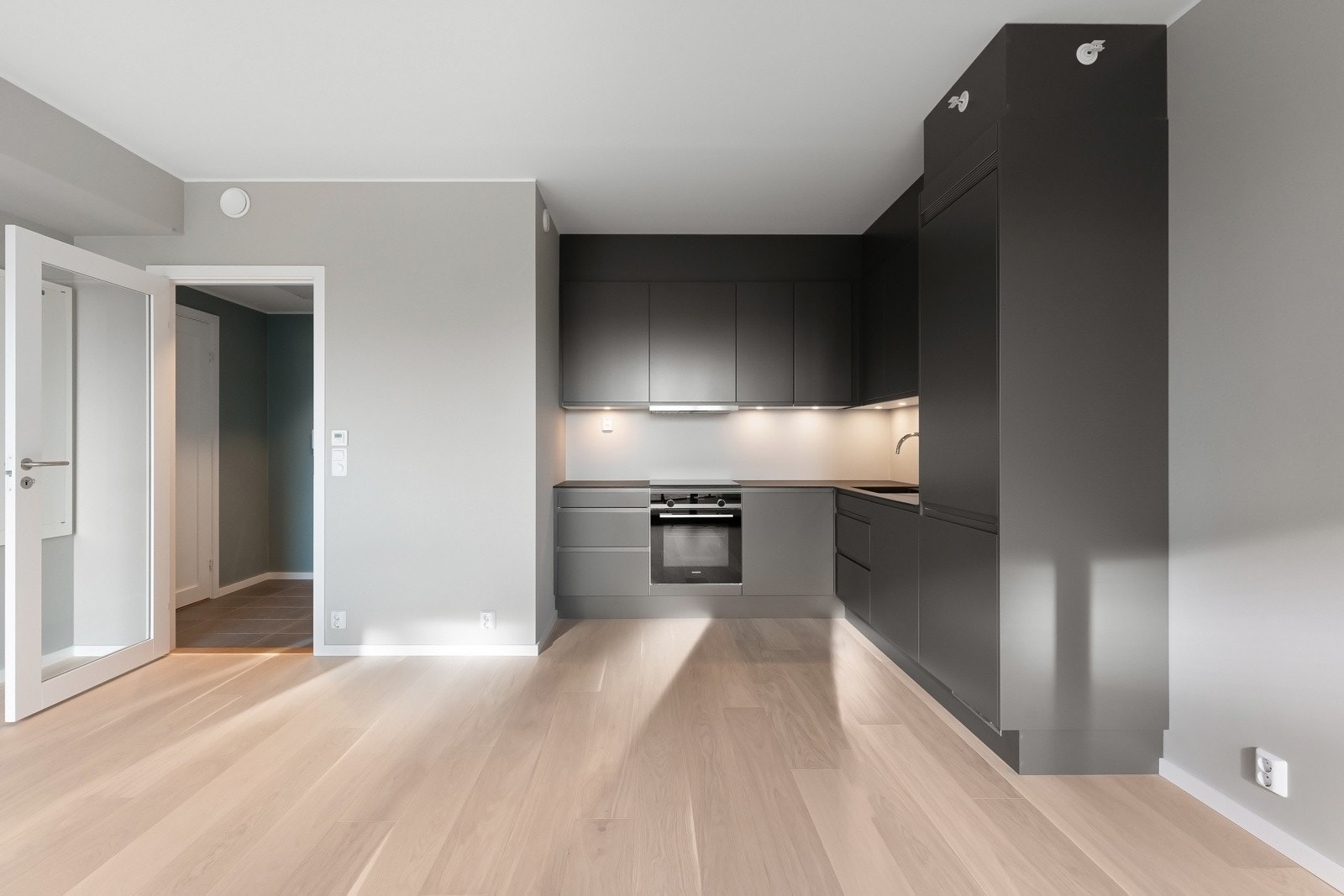 I en åpen løsning mot stuen finner du et stilrent og delikat kjøkken fra Sigdal med glatte fronter og benkeplate av laminat. Galleribilde