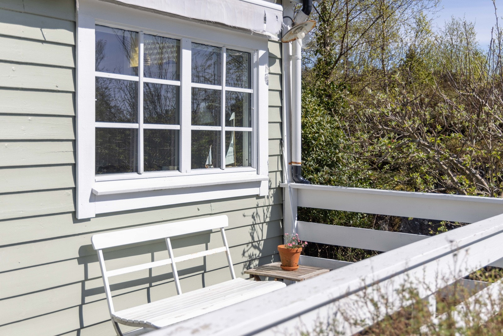 Terrassen i front bader i ettermiddags- og kveldssol - et naturlig samlingspunkt. Galleribilde