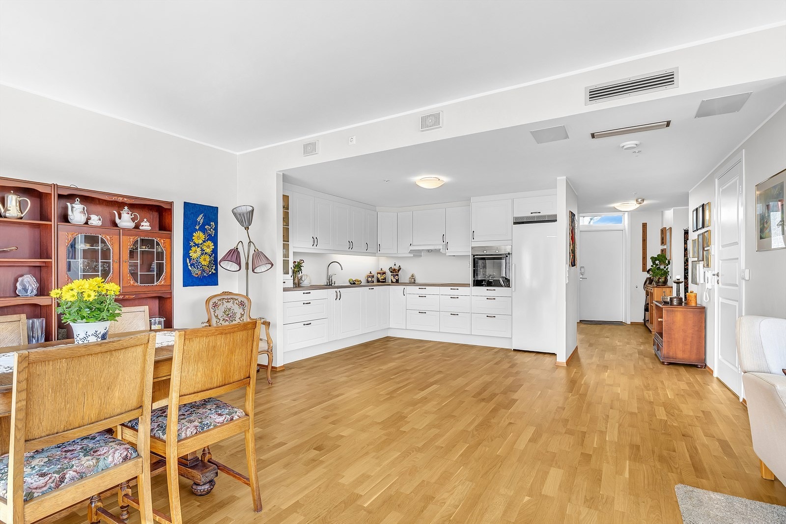 Stilrent kjøkken med hvite fronter og laminert benkeplate med nedfelt stålvask. Galleribilde