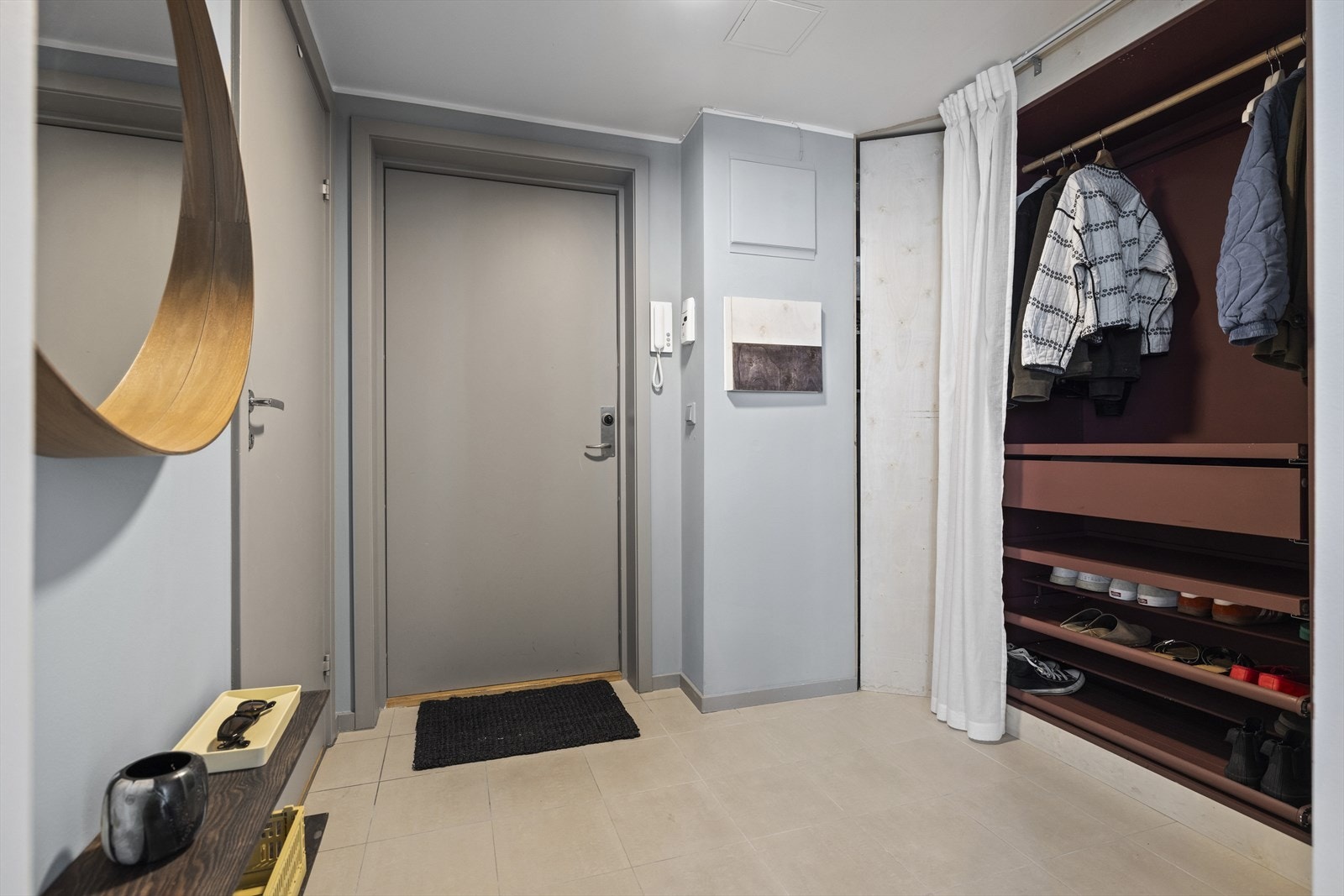 Lys og praktisk entré som gir et godt førsteinntrykk av leiligheten. Her har du god plass til oppbevaring av ulike klesartikler i praktisk garderobeskap Galleribilde