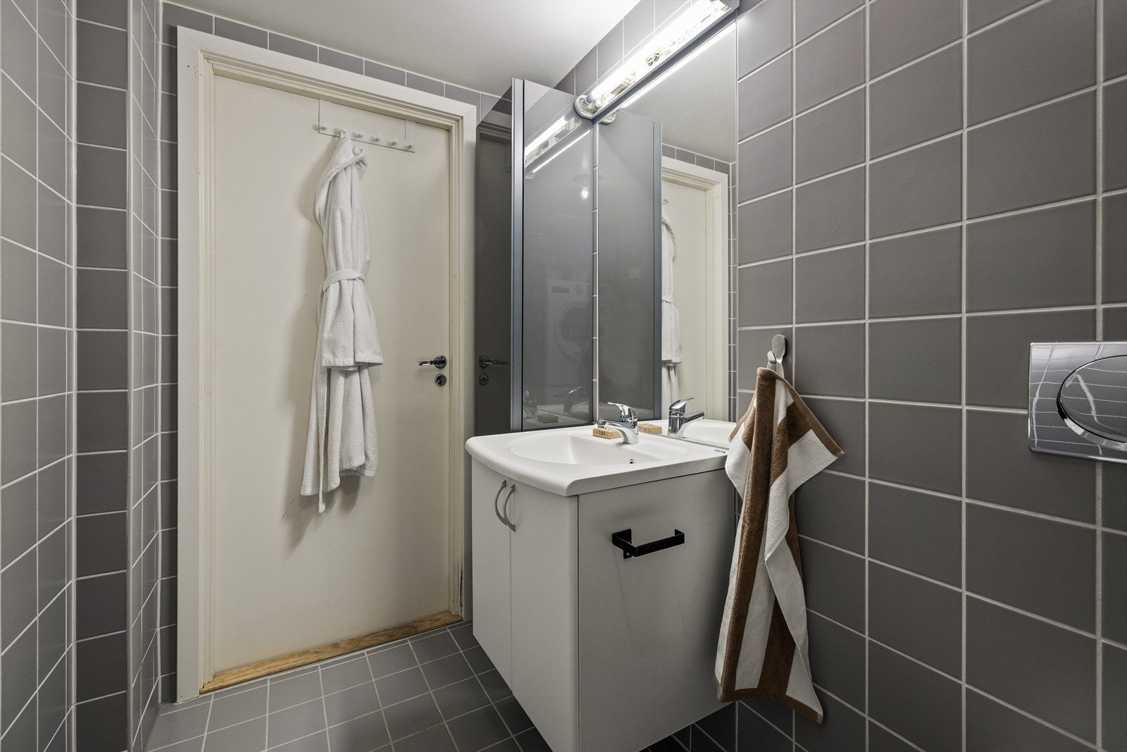 Innredningen inkluderer benkeskap med glatte fronter og servant i helstøpt plate Galleribilde