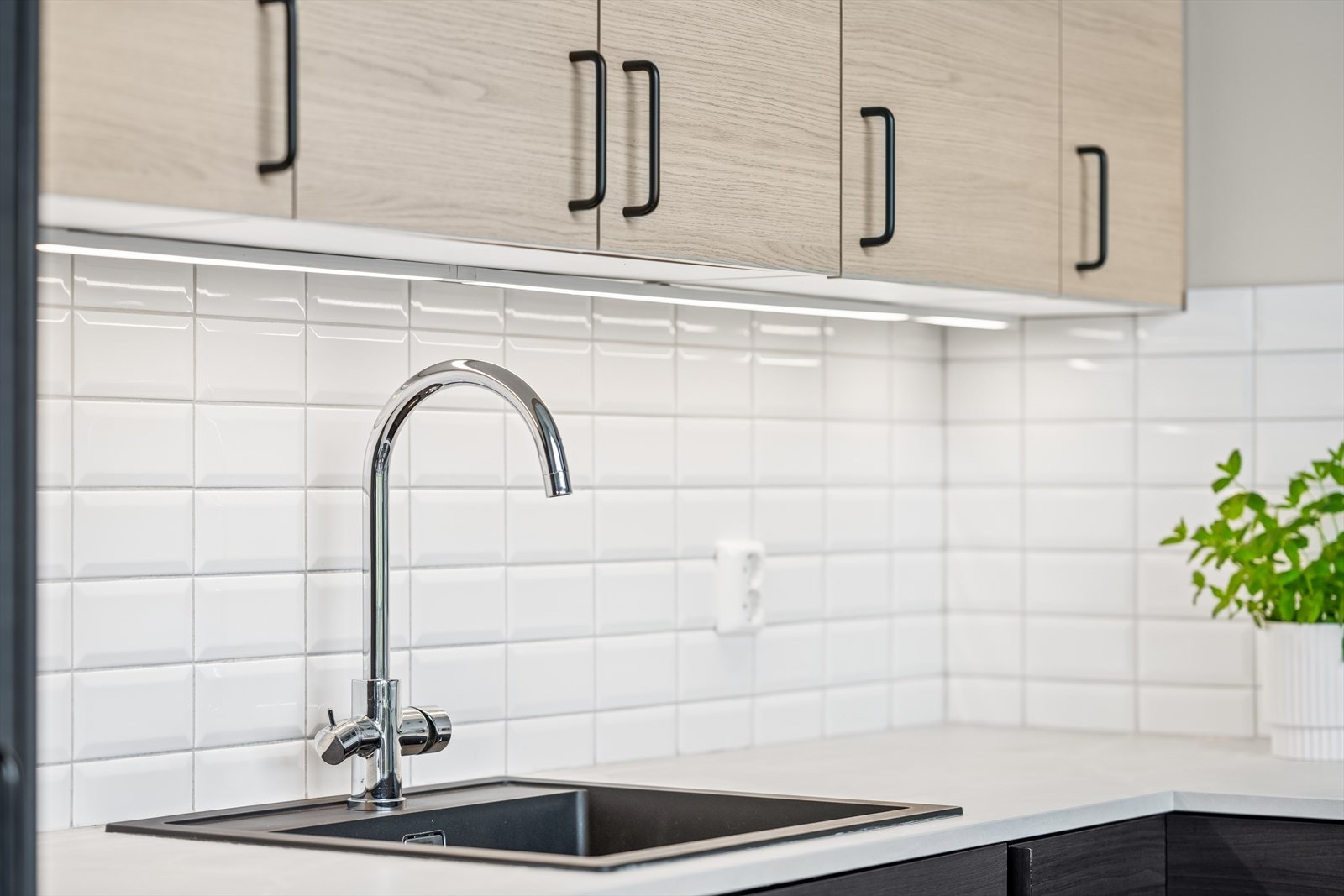 Kjøkkenet har innredning med glatte fronter. Benkeplaten er av høytrykks laminat med nedfelt kum. Integrert kjøl/fryseskap, oppvaskmaskin, stekeovn og
indukjsonstopp. Galleribilde