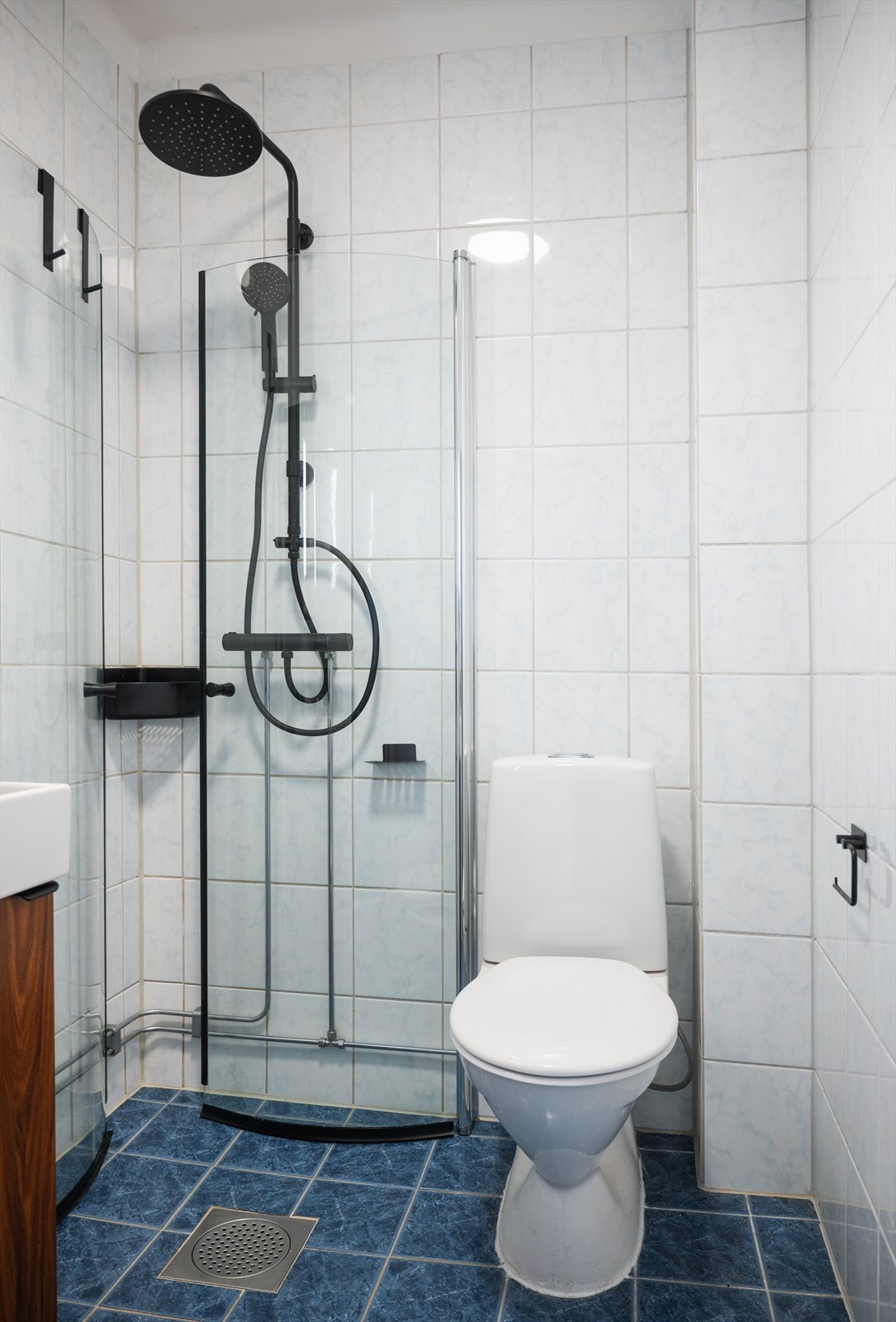 Badet er utstyrt med gulvstående toalett, servantinnredning med servant, ettgreps blandebatteri, blandebatteri/dusjarmatur og dusjdører i glass. Galleribilde