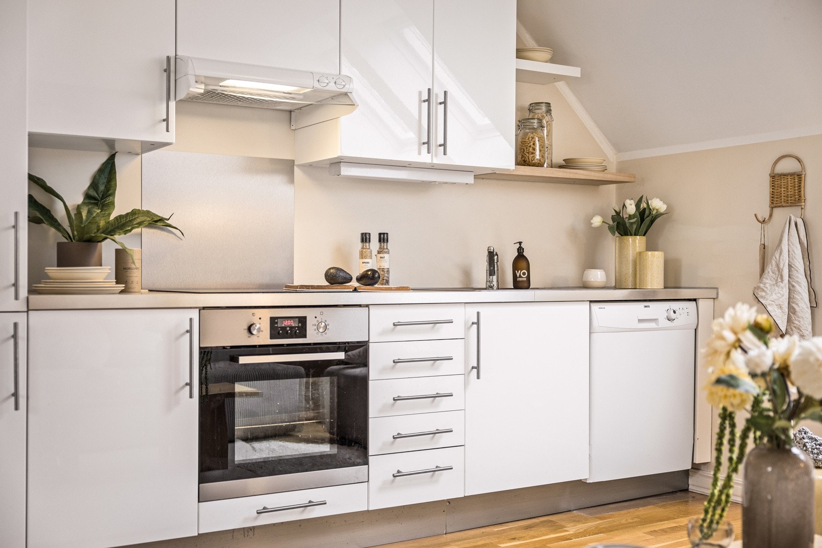 - Kjøkkenet har en stilren og nøytral innredning, perfekt for en åpen kjøkkenløsning som denne. Det er integrerte hvitevarer, herunder stekeovn, platetopp med induksjon og kjøleskap med frysedel. Kjøkkenet har opplegg for oppvaskmaskin - Galleribilde