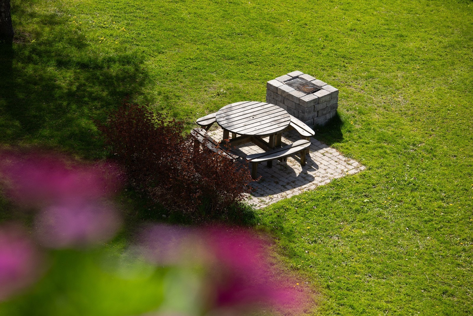 Pent opparbeidede fellesområder på borettslagets tomt med diverse benker, grill og for øvrig grønne plener. Galleribilde
