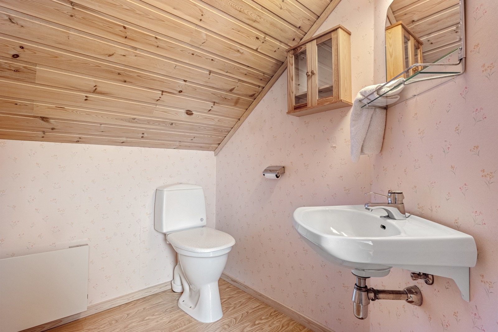 Toalettrom med belegg på gulvet og tapet på vegger. Galleribilde