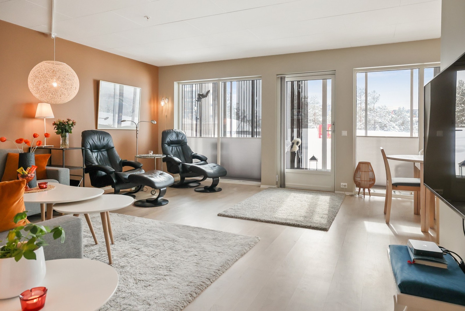 Herfra åpner boligen seg til en lys og åpen stue med store vinduer som slipper inn rikelig med dagslys. Galleribilde