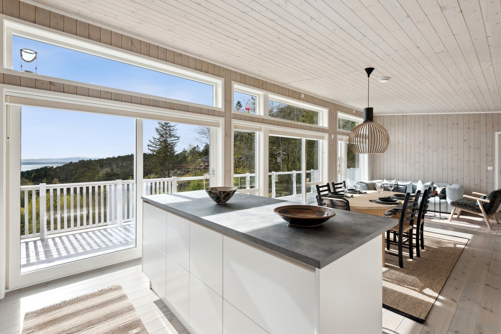 Romslig stue med store vindusflater og nydelig utsikt utover fjorden. Galleribilde