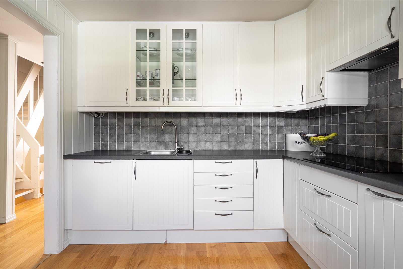 Integrerte hvitevarer medfølger som stekeovn, mikro, platetopp, oppvaskmaskin og kjøl/frys. Det er også plass til et lite spisebord ved vinduet. Galleribilde