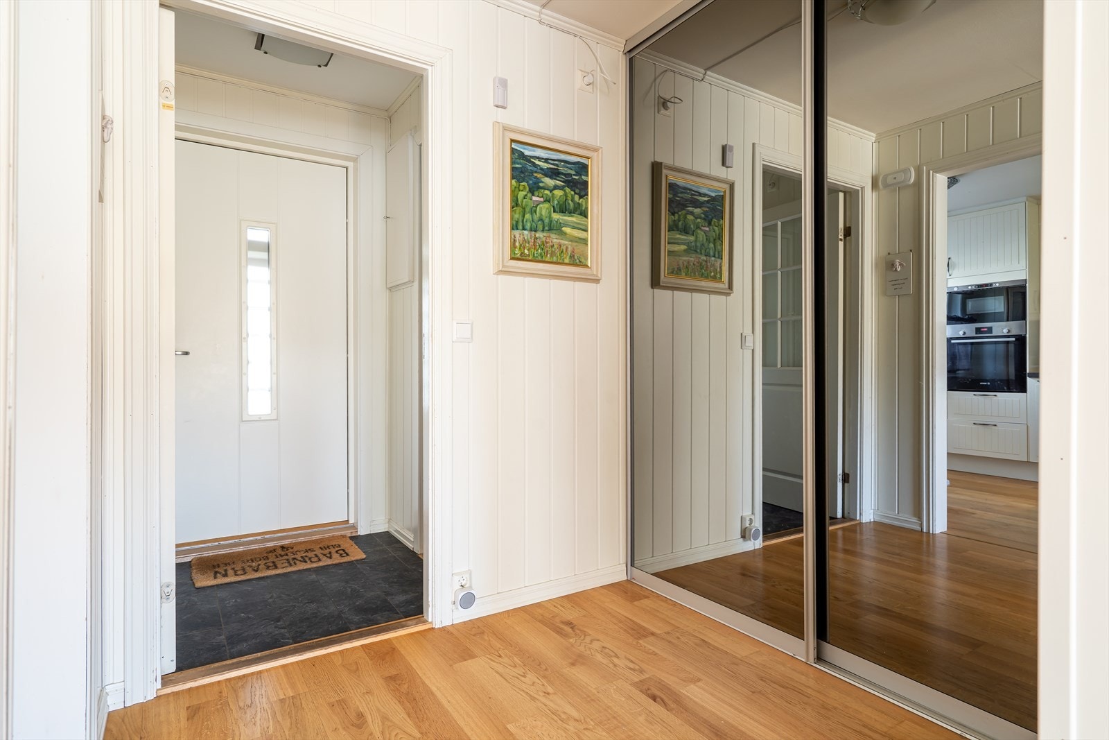 Når du kommer inn i boligen har du først en liten gang hvor det også er tilknyttet toalettrom. Videre kommer du inn i en større gang som har stor skyvedørsgarderobe med speildører. Galleribilde