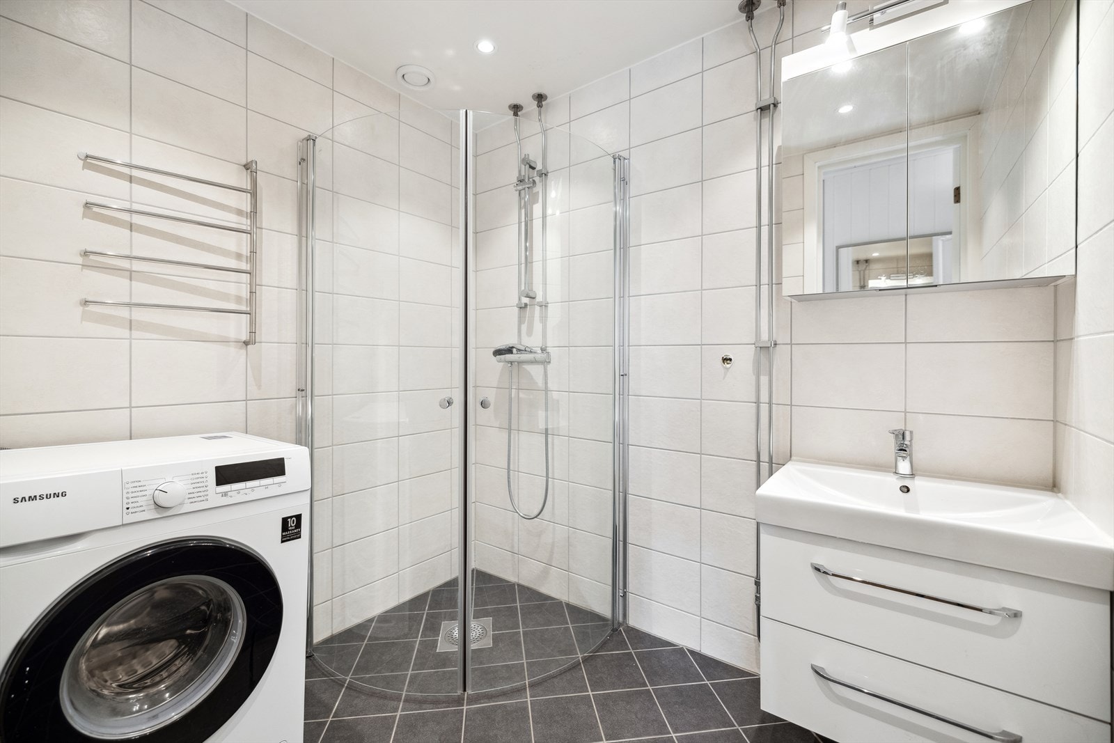 Bad med gulv og vegger med fliser, opplegg for vaskemaskin. Galleribilde