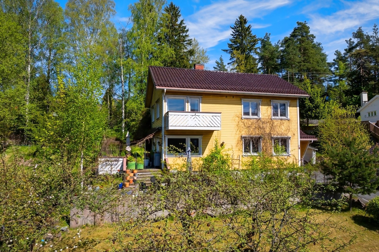Boligen er omgitt av frodige trær og natur. Galleribilde