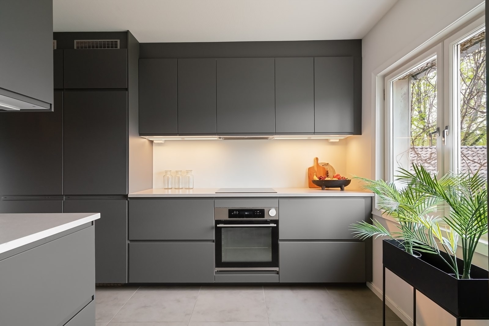 Innredningen er av merket Ikea og består av mørkegrå, slette fronter, gripetak og benkeplate av stein. Galleribilde