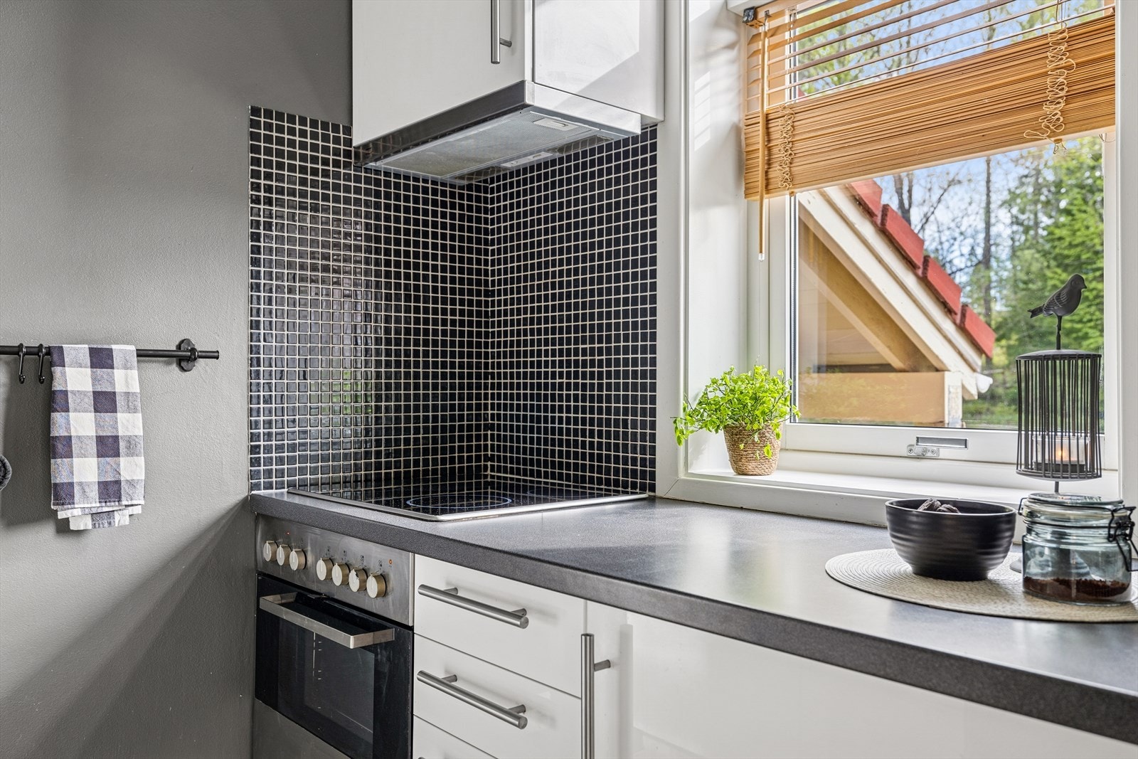 Innredningen har lyse slette fronter, laminat benkeplate med nedfelt oppvaskkum, fliser over benk og ventilator. Galleribilde