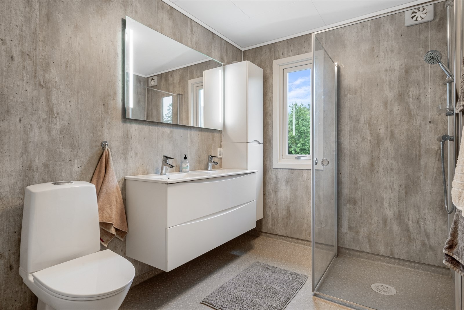 Badet ble renovert i 2022. Rommet har behagelig varme i gulvet og er innredet med lys og stilren innredning. God oppbevaringsplass i servantskap og høyskap. Galleribilde
