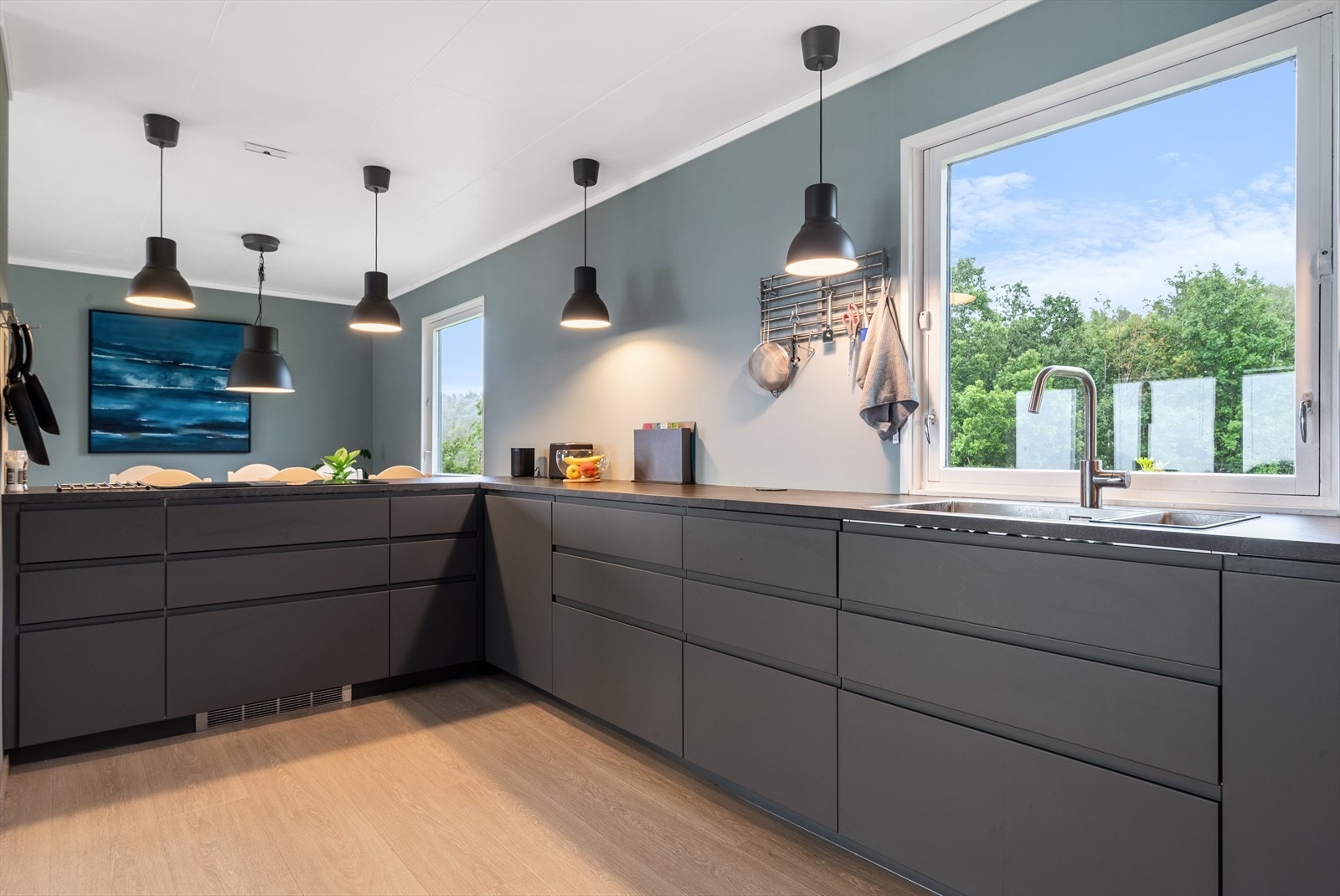 Moderne innredning med nedfelt vask og nedfelt induksjonstopp med avtrekk. Integrert oppvaskmaskin, stekeovn, micro og kjøl/fryseskap medfølger i handelen. Galleribilde