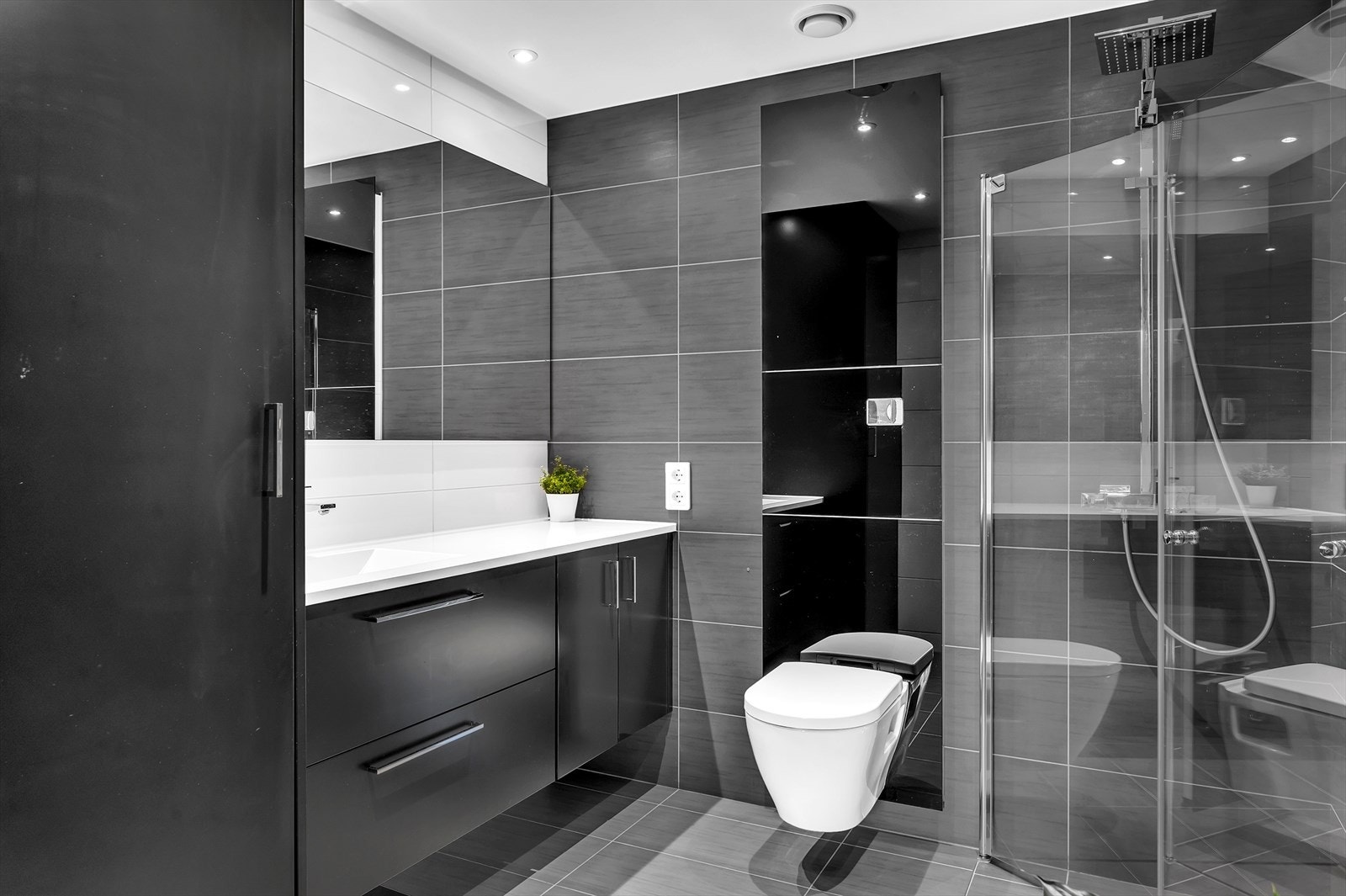 Flott flislagt bad med inngang fra hovedsoverom. Badet har dusjhjørne, vegghengt toalett, servant samt opplegg til vaskemaskin og tørketrommel. Galleribilde