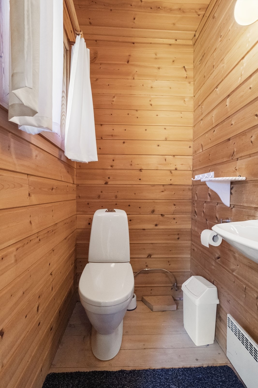 - Toalettrom med enkel innredning som består av servant, speil og toalett - Galleribilde