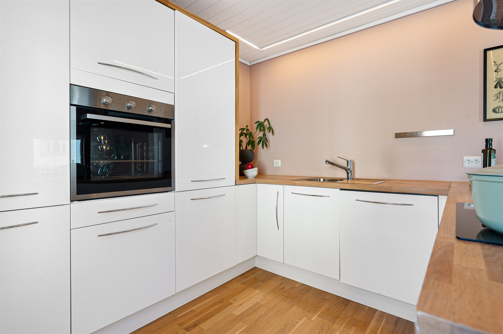 Kjøkkeninnredningen er i tidløs hvit med heltre benkeplate og spiler på benk. Det er rikelig med skapplass og benkeflater, integrerte hvitevarer. Galleribilde