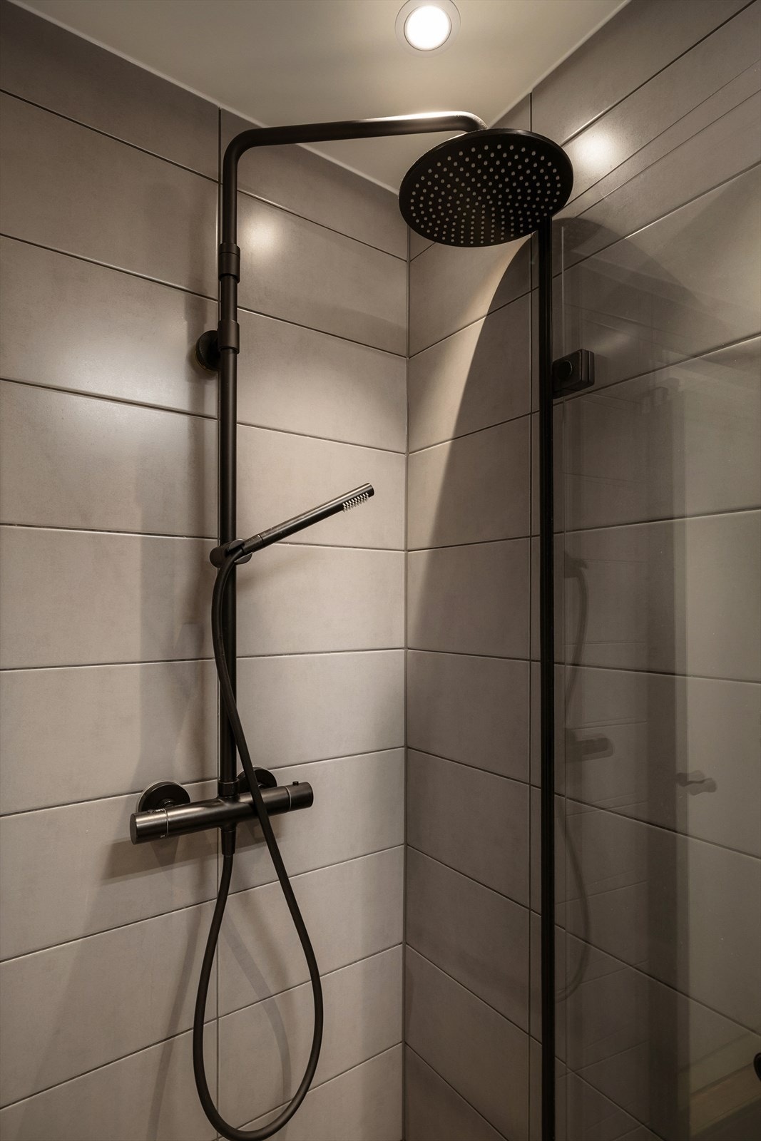 Badet har moderne fliser på gulv og vegger, gulvvarme og downlights med dimmer på bad. Galleribilde