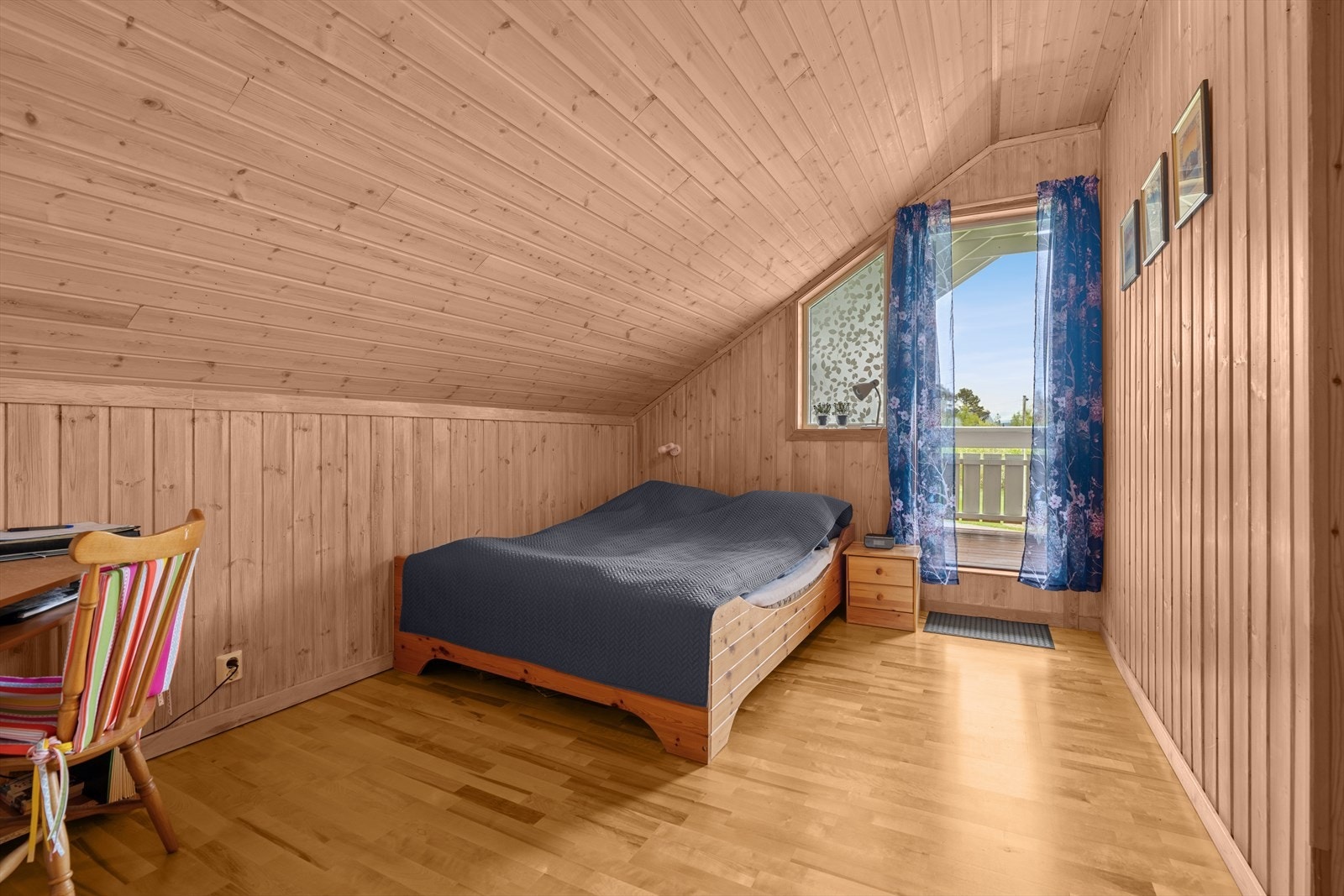 Et av soverommene i loftsetasje har utgang til overbygd veranda med fin utsikt. Galleribilde