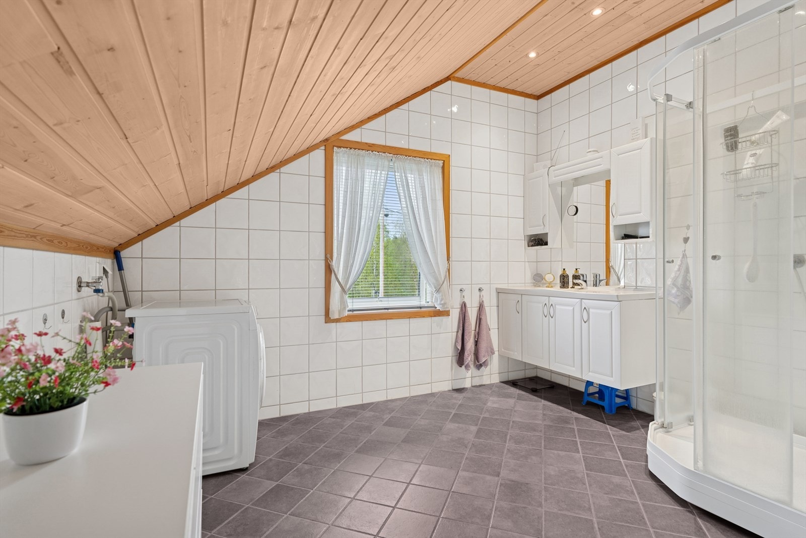 Baderom utstyrt med nedfelt servant, toalett og dusjkabinett med glassdører. Galleribilde