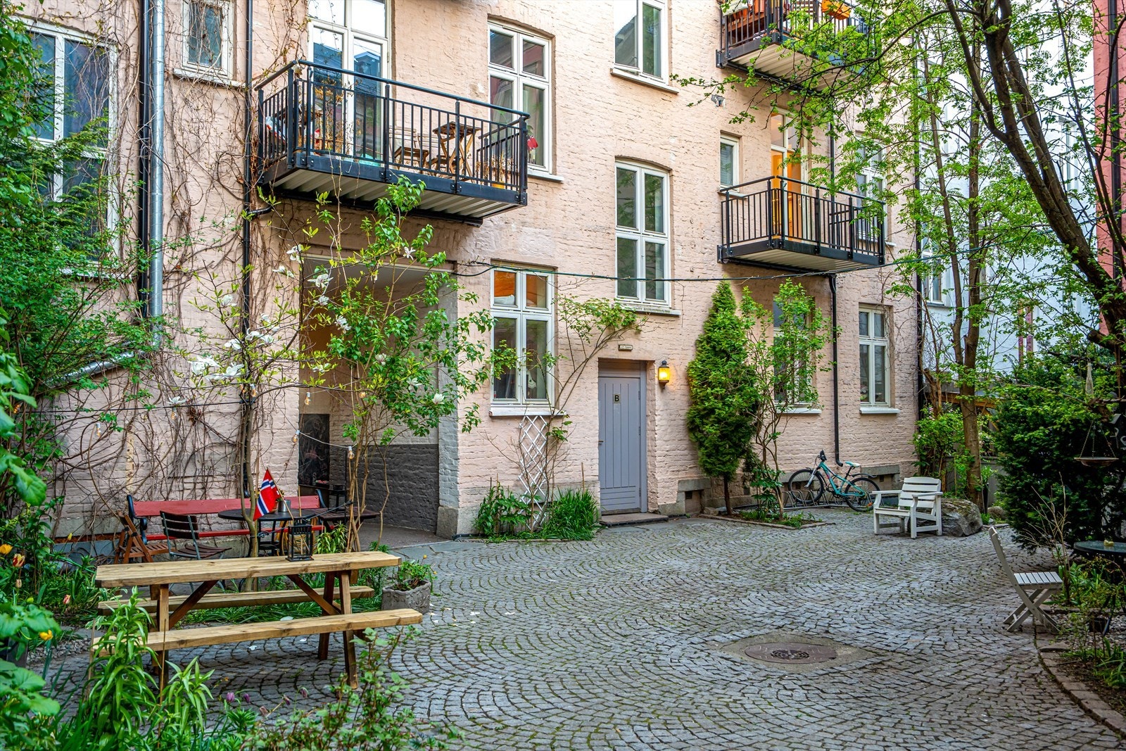 Koselig og velstelt bakgård med sykkelparkering og sittebenker. Galleribilde