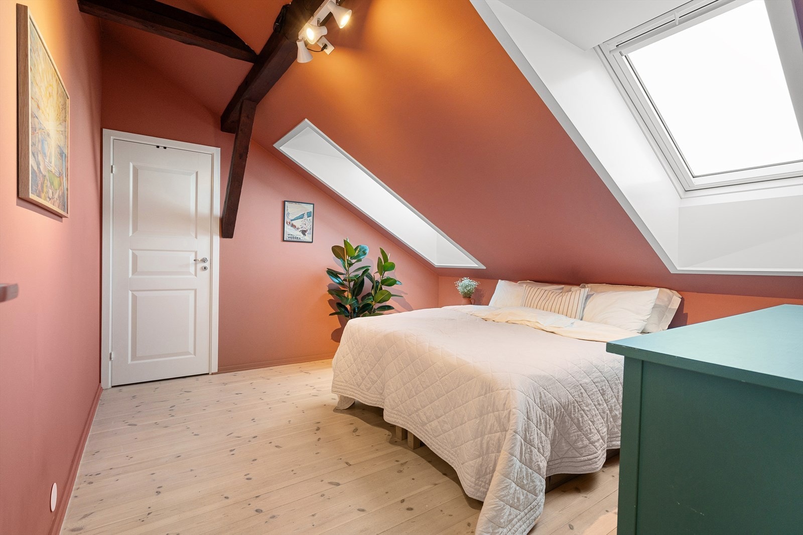 Sjarmerende soverom med to store takvinduer, lun farge på veggene og bjelker i taket. Galleribilde