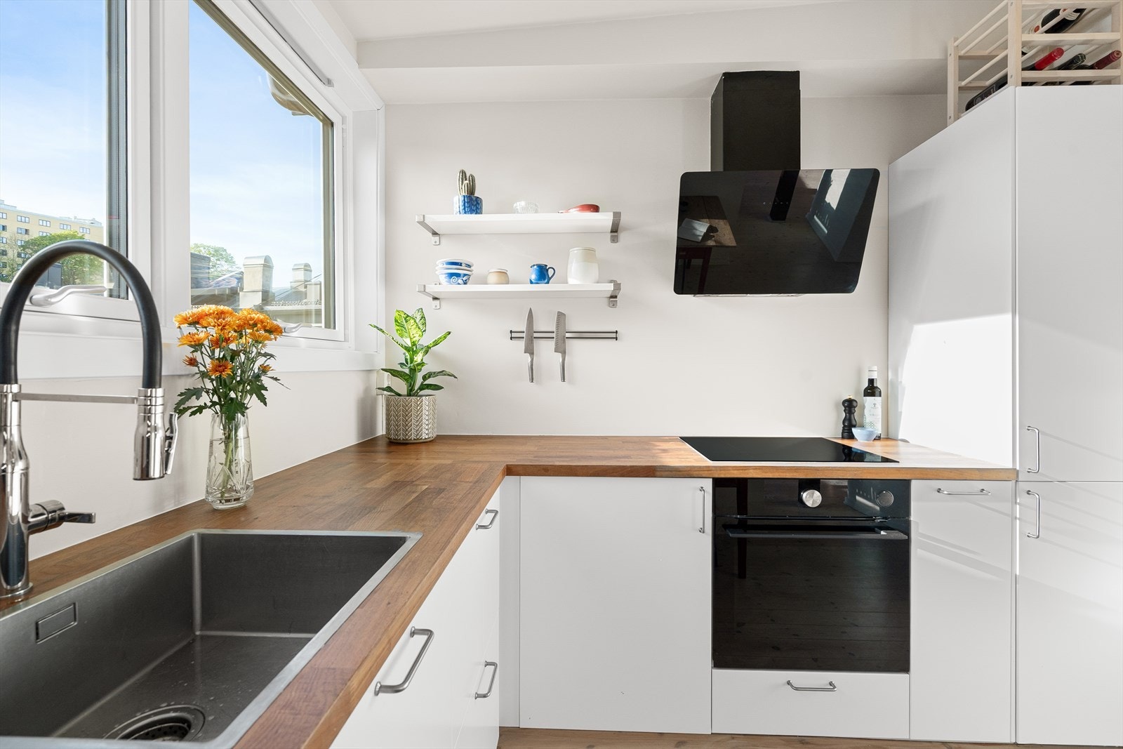 Vifte plassert over integrert koketopp/ovn, integrert kjøl/frys og integrert oppvaskmaskin. Det er kjøkkenventilator med avtrekk ut. Galleribilde