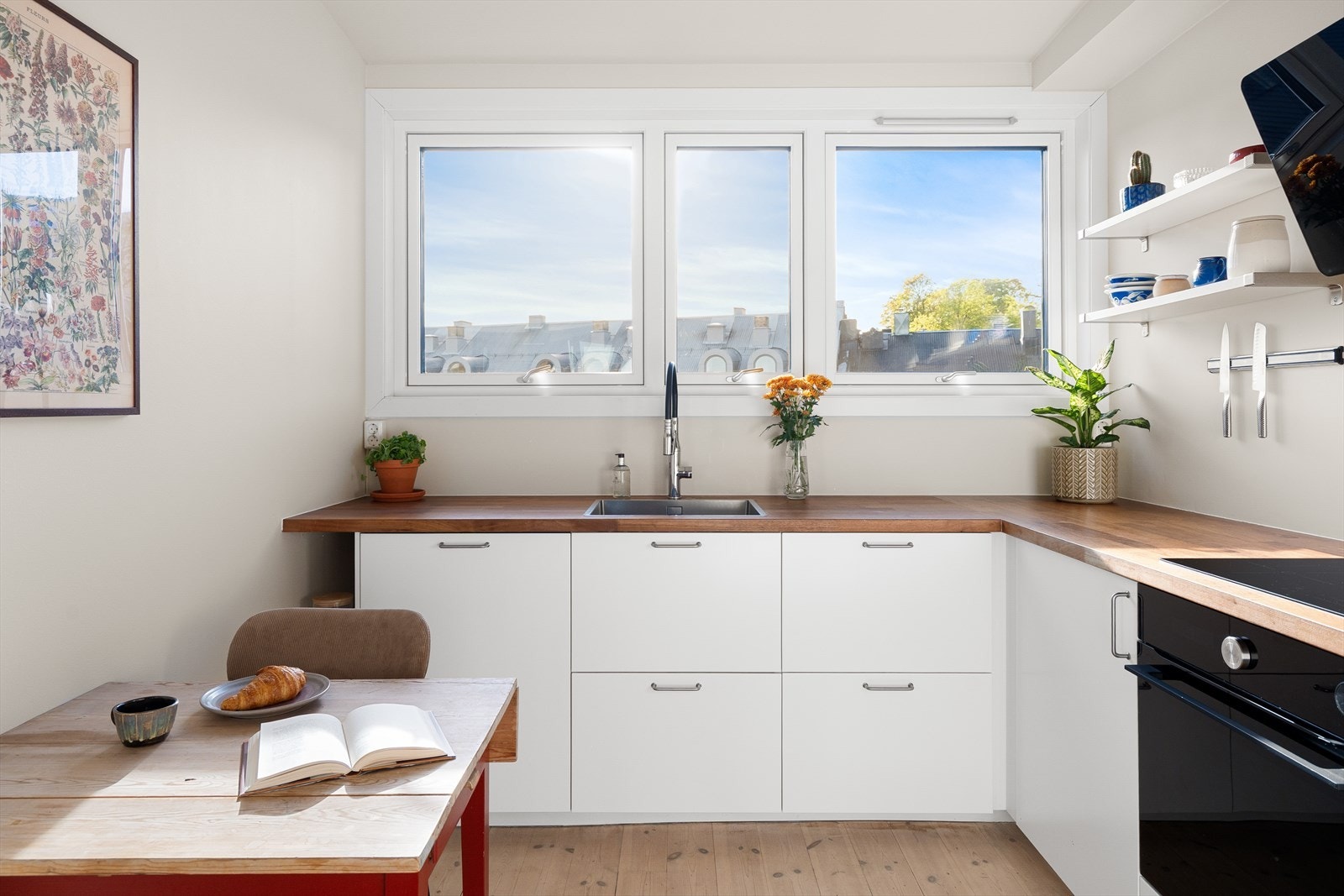 Innredet med hvit laminert kjøkkeninnredning, benkeplate i tre, kum med ettgreps blandebatteri. Galleribilde