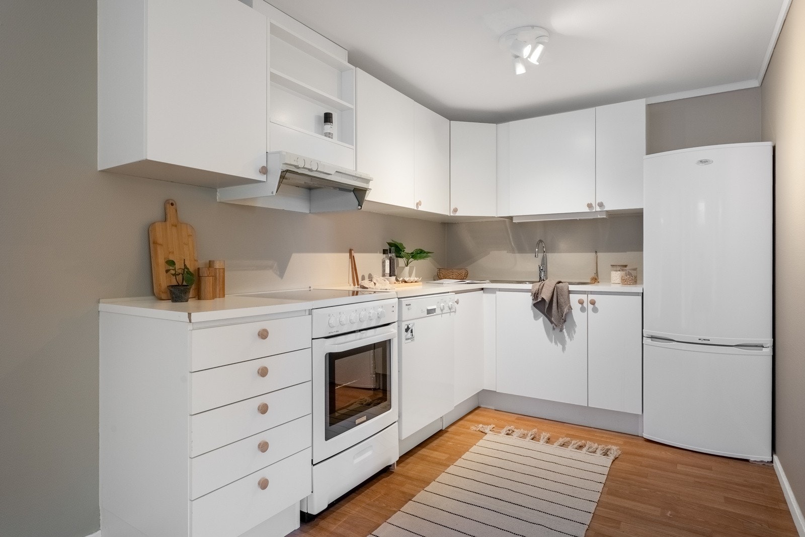 Kjøkkeninnredning med hvite glatte fronter og laminert benkeplate. Galleribilde