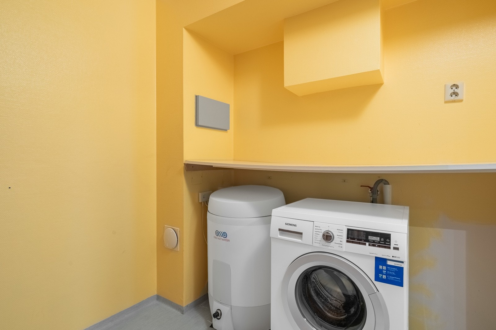 Innenfor badet er det en bod med opplegg for vaskemaskin og lagringsmuligheter. Galleribilde