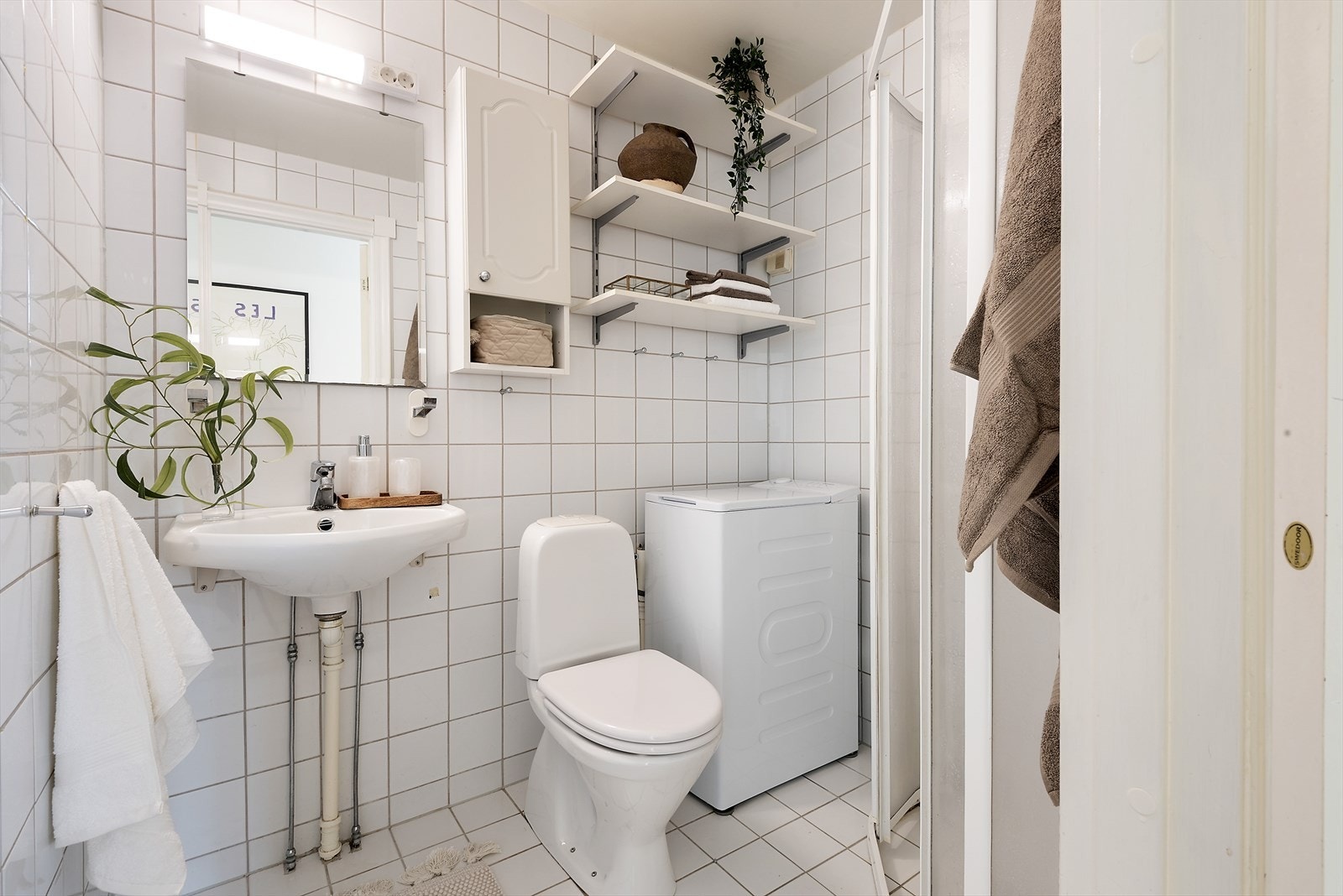 Flislagt gulv og vegger, elektriske varmekabler og tak malt i hvitt. Galleribilde