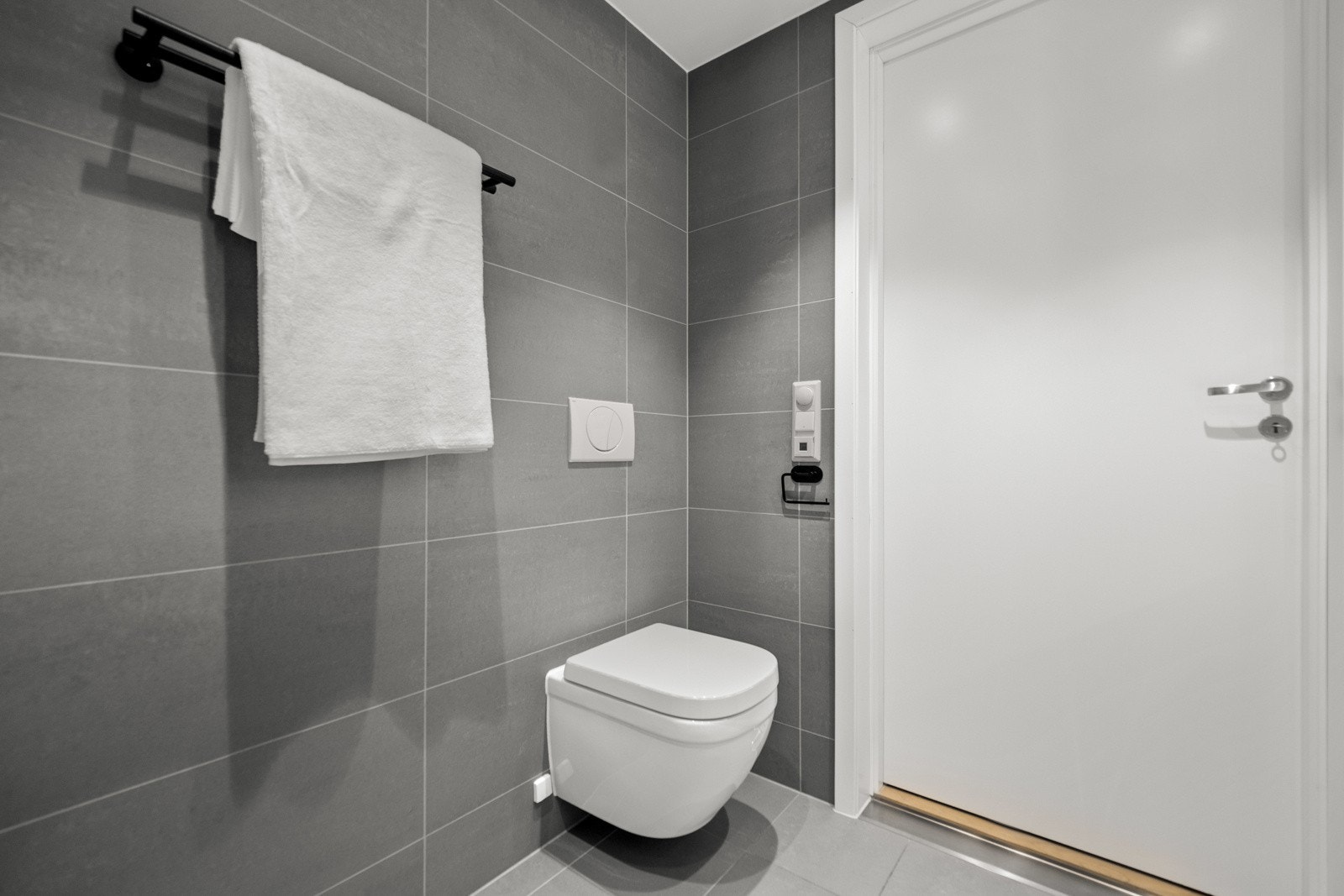Badet er moderne og lettstelt med flislagte overflater, downlights og veggmontert toalett. Galleribilde