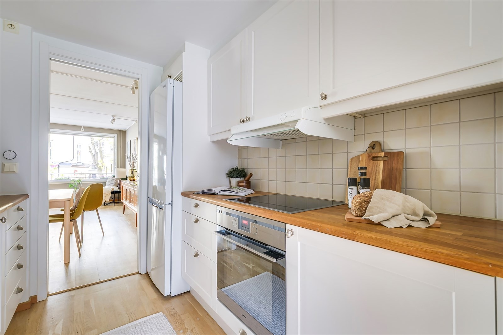 Pent og tidløst kjøkken med integrerte hvitevarer som stekeovn, induksjonsplatetopp, mikrobølgeovn og oppvaskmaskin (2022). Det er plass til frittstående kjøleskap. Galleribilde