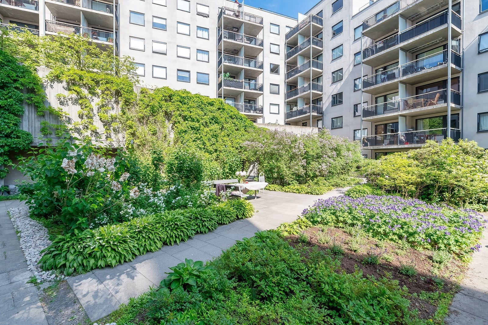 Med hellelagte gangveier og variert beplantning får man nesten følelsen av å sitte i en botanisk hage. Galleribilde